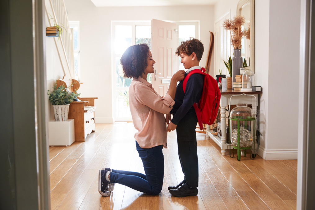 Kindergarten Reading: Getting Your Kid Ready Mom putting finishing touches on son's outfit before leaving for school.